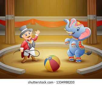 Circus ringmaster performs a trick along with elephant in arena