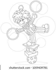 Circus show of a comic juggler - equilibrist. Friendly smiling clown balancing on several objects and juggling with hoops, a black and white vector illustration in a cartoon style for a coloring book