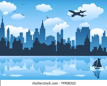 city in blue sky and its reflection on water