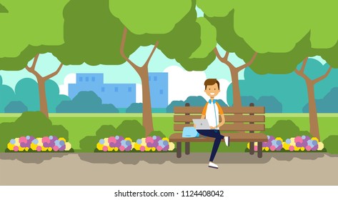 city park man holding laptop sitting wooden bench green lawn flowers trees cityscape template background flat vector illustration