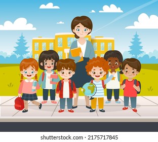 Classmates standing with teacher in front of the school. Diverse pupils group photo.