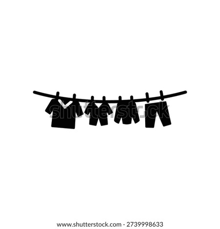 Clean and modern flat lay of black minimalist clothing including shirt, pants, and shorts neatly hung on wooden hangers against white background.