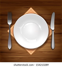 Clean plate with knife, fork and napkin on wooden background.