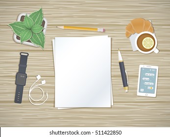 Clean sheets of paper on the desktop. Top view of paper, pen, pencil, smartphone with message of the screen, headphones, smart watch, tea with lemon, pot. Preparation for work, notes, sketches.