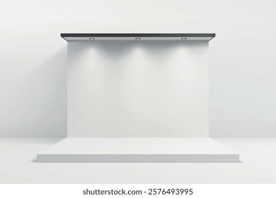 A clean white exhibition backdrop illuminated by three black spotlights on a raised platform