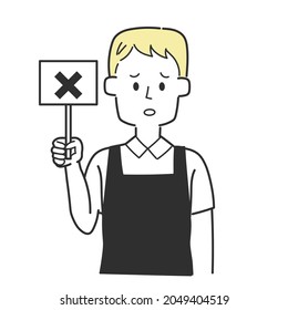 A clerk in an apron holding a tag with a cross