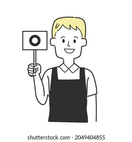 A clerk wearing an apron holding a circle-written tag