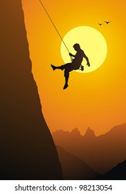 The climber goes down from the rock on a rope