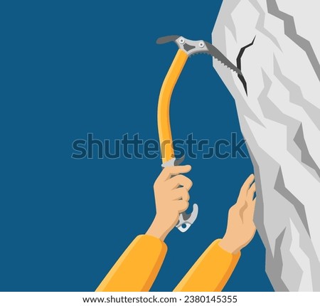 Climbing the rocky mountain using ice axe - alpinism tool in hand