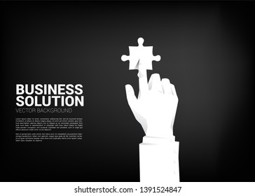 close up businessman hand touch jigsaw piece. business concept of solution and matching.