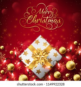 Close up of Christmas golden box dress up background with string lights through the box and balls,lettering text on top flowing in the air along with bokehs all the time