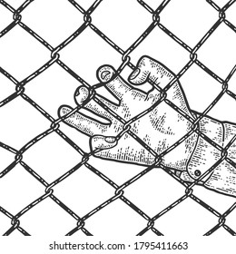 Close up of the fingers of a man hand on a metal fence