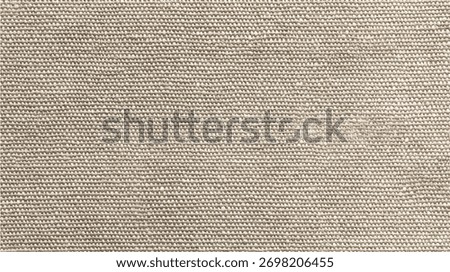 Close up view of a woven burlap fabric texture with visible threads and a neutral beige brown color weave