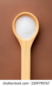 close up wooden spoon full of salt