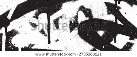 A close-up of a black and white graffiti artwork featuring bold, abstract shapes and dripping paint, creating a raw and urban aesthetic.