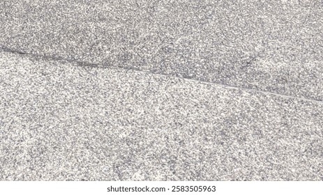 a close-up of a granite ceramic surface with a fine, speckled texture. The material appears smooth yet slightly rough due to its granular composition, commonly used for flooring or wall cladding.