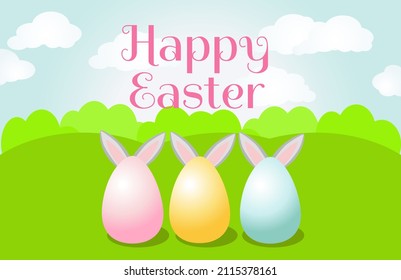 Close-up of painted eggs on green grass with rabbit ears sticking out behind the eggs. Horizontal banner with green meadow and blue sky and text Happy Easter. 