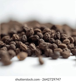 A close-up shot reveals a pile of dark brown seeds, possibly from a plant, scattered on a white surface, with a blurred background suggesting a larger quantity of the same seeds.