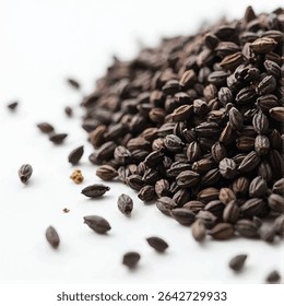 A close-up shot reveals a pile of dark brown seeds, possibly black caraway seeds, scattered on a white surface, with a few seeds dispersed around the main pile.