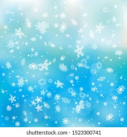 Closeup snowfall on blue sky backdrop. Winter holiday Christmas background. Big and small snowflakes falling from clouds