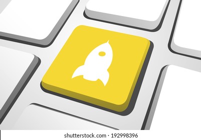 Close-up of yellow rocket computer icon on a keyboard button.