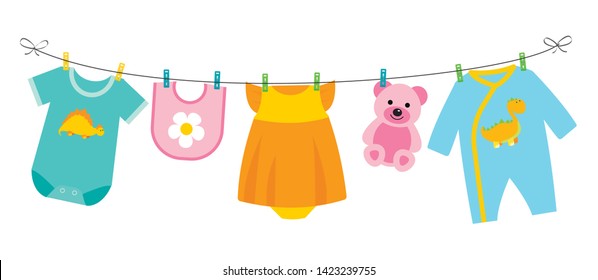 Children’s clothes and toy hanging on the clothesline. Bib, sliders, bodysuit, dress and other.