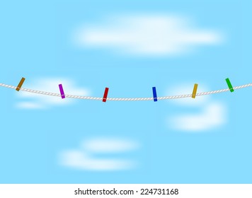 Clothespins on white rope and blue sky