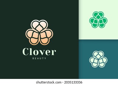 Clover leaf logo in luxury gold color represent lucky or herb