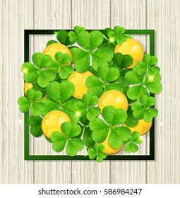Clover leaves and golden coins in green frame on a wooden background. Abstract design for St. Patrick's day.
