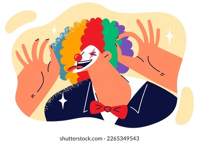 Clown sticks out tongue and makes funny faces to audience laugh at circus or humorous theatrical performance. Clown brings joy to people during festive comedy show designed to cheer up others 