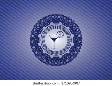 cocktail glass icon inside badge with denim texture. 