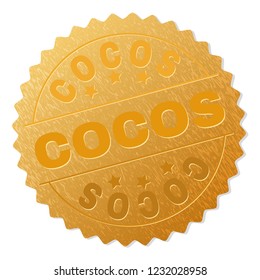 COCOS gold stamp medallion. Vector golden award with COCOS text. Text labels are placed between parallel lines and on circle. Golden skin has metallic structure.