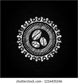 coffee bean icon inside chalk emblem written on a blackboard
