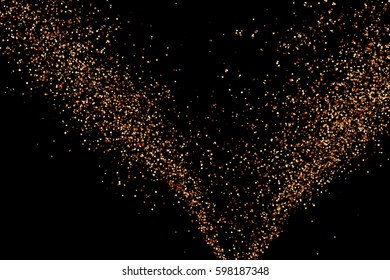 Coffee color grain texture isolated on black background. Chocolate shades confetti. Brown particles