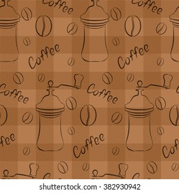 Coffee grinder and coffee beans on a brown squared background.