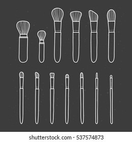 Collection of different hand drawn outline makeup brushes isolated on the blackboard.