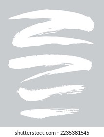 Collection of miscellaneous grunge brush strokes in white isolated over light grey background. Set of design elements. Vector illustration.