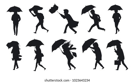 collection of people walking under the rain storm wind with umbrellas