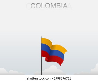 Colombian flag flying on a pole standing tall under a white sky