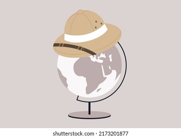 A colonial hunter cork hat, a symbol of colonialism and usurpation sitting on top of a round Globe on a metal stand