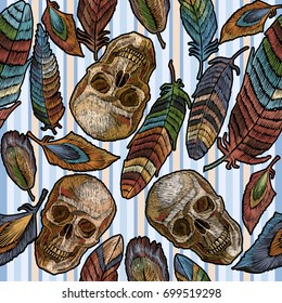 Color feathers and indian skull boho embroidery seamless pattern in blue stripes. Beautiful feathers of tropical birds and human skull classic embroidery seamless pattern 