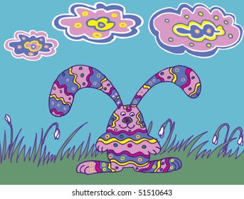 The color rabbit are among the grass and spring flowers.