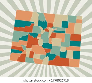 Colorado map. Poster with map of the us state in retro color palette. Shape of Colorado with sunburst rays background. Vector illustration.