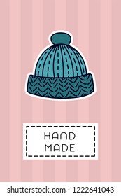 Colored badge with knitted wool cap. "Hand made" sign on simple background. Simple knit / crochet emblem design. Doodle hand draw art. Wool handmade shop logo or tag for masters.
