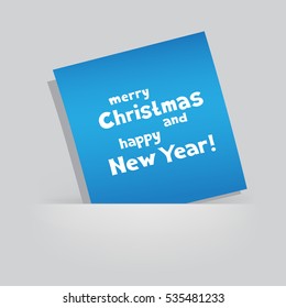 The colored blue piece of paper with the message of Christmas greetings on gray pocket