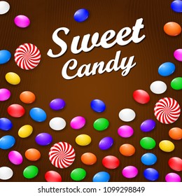 Colored candies, sweets and lollipops. On a brown wooden background. View from above.