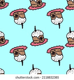 colored Easter cake pattern with a candle on blue. seamless pattern of brown Easter cupcakes, doodles with white icing and pink sprinkles on top, hand-drawn on blue for a bright Easter design template