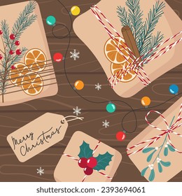 Colored garland and Christmas gifts in eco craft paper with organic plant decorations on dark wooden surface. Ecological packaging. Xmas cozy square background. Preparing for winter holidays