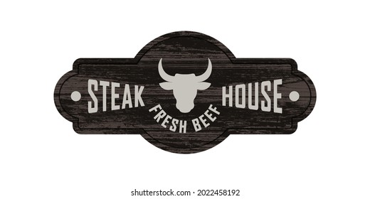 Colored illustration of a bull's head, text on a background with a wooden texture. Design element for signboard, banner, emblem, label. Vector illustration. Steak house advertisement.