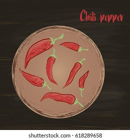  Colored pods of chili peppers in a round bowl drawn with chalk on a black board. View from above.